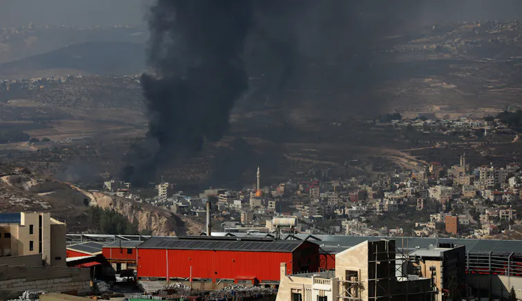 Smoke rises after an Israeli settler attack on a town on the West Bank.