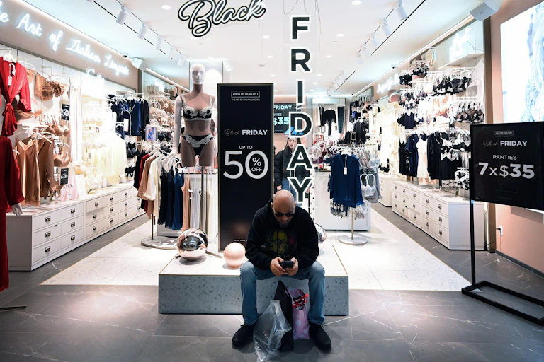 A man on his mobile phone in front of a shop