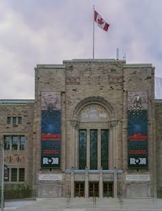 A Canadian flag seen atop a museum.