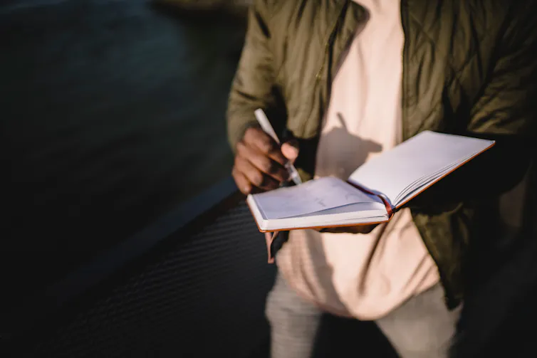 A man writes in a diary.