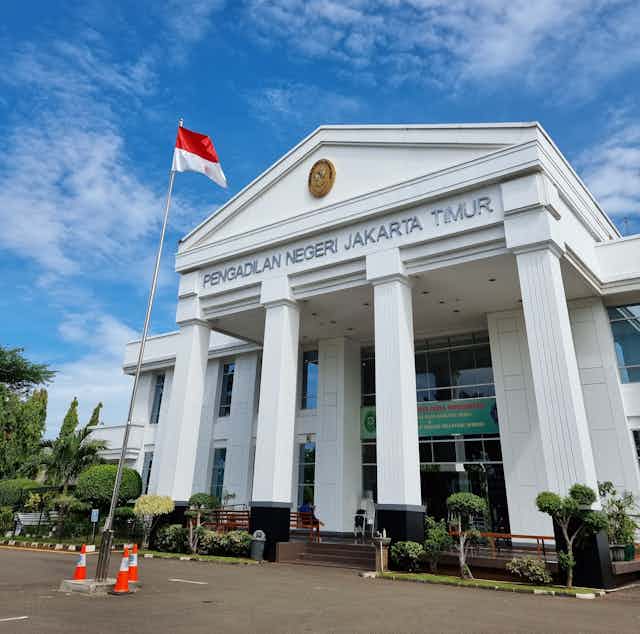 Exterior of large, white court building with four columns in Jakarta, Indonesia