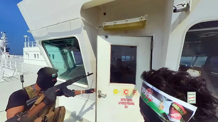 Masked man holding machine gun breaking through a door