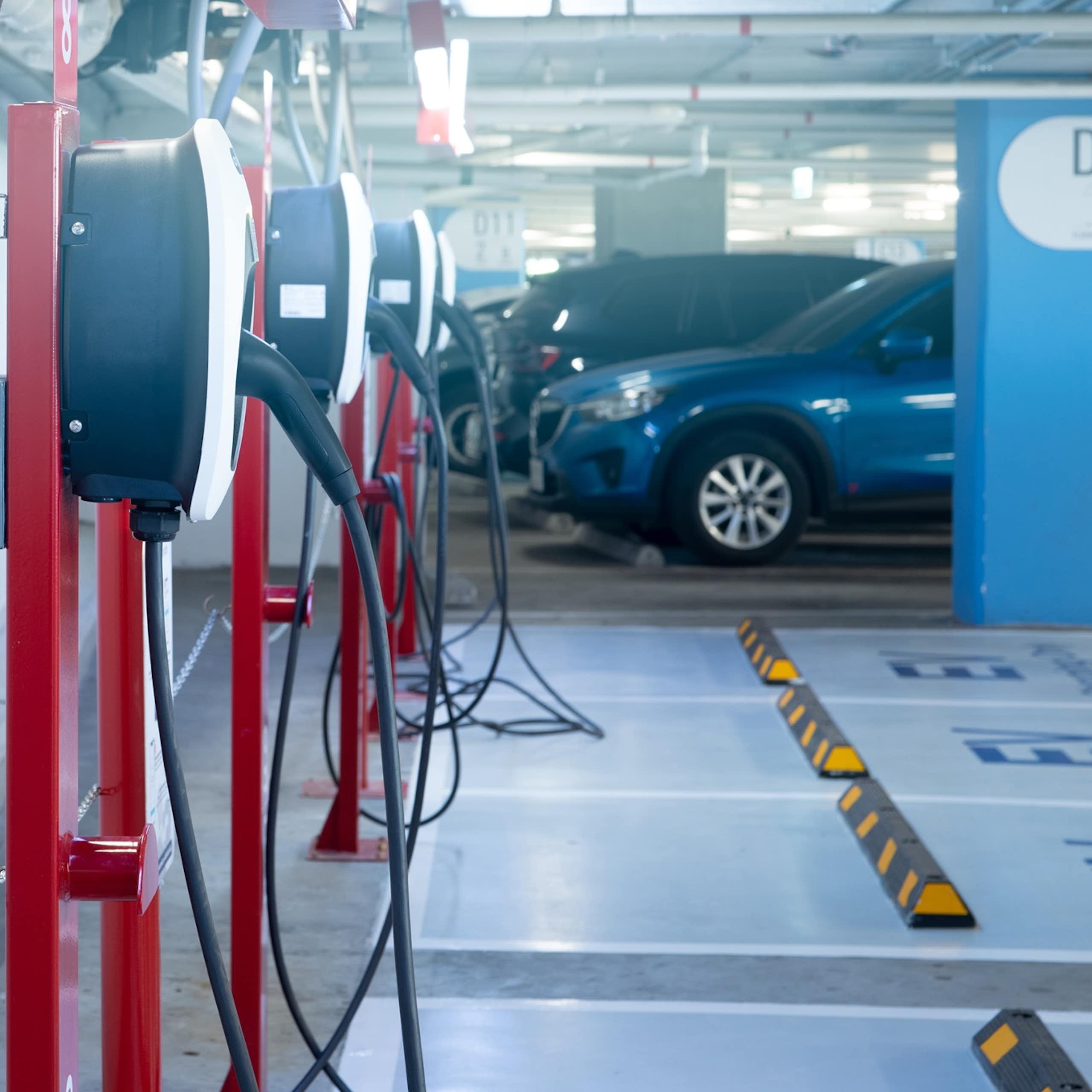 Un aparcamiento con coches y estaciones de carga