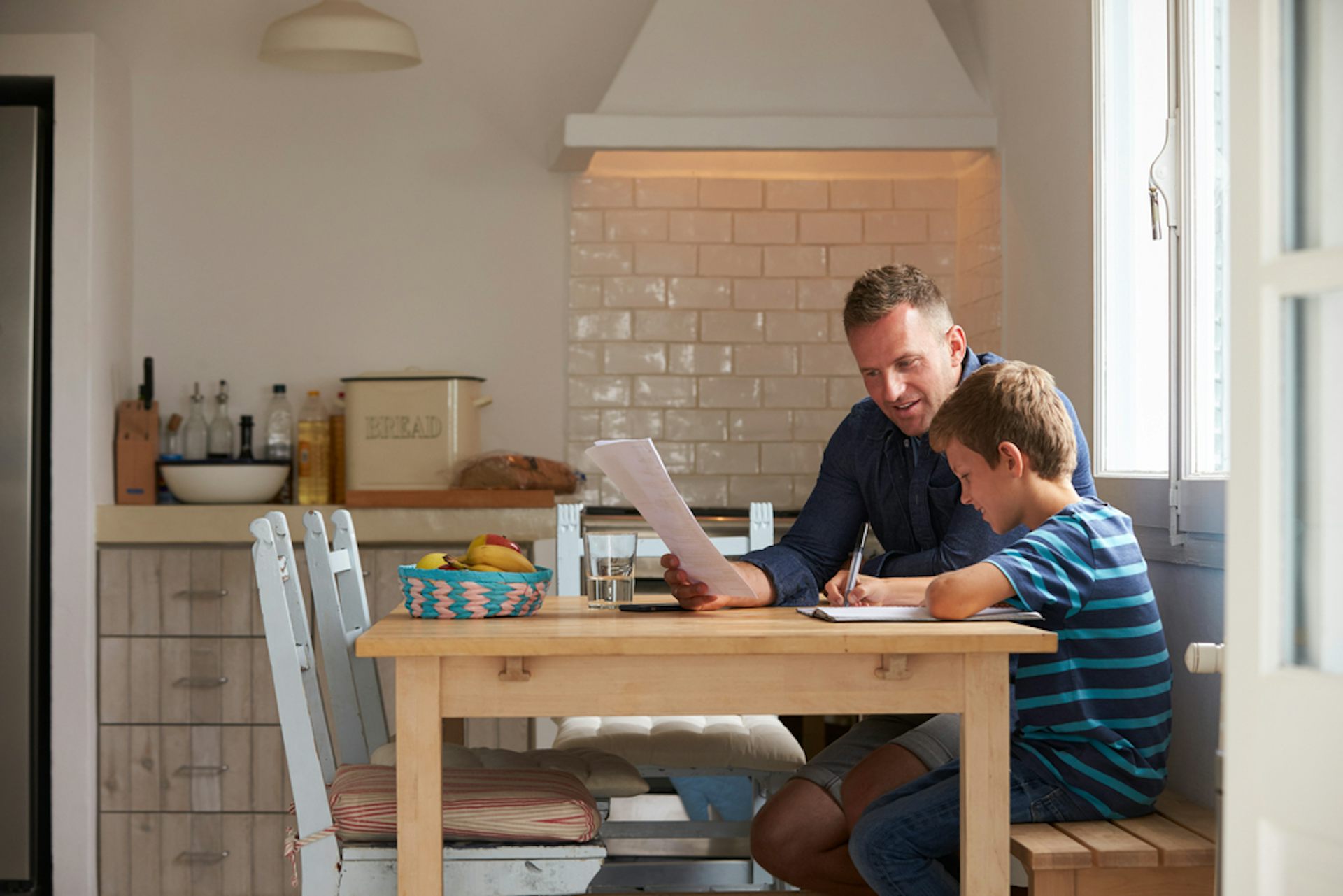 Père aidant son fils à faire ses devoirs