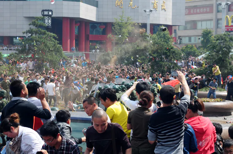 Chinese protestors clashing with armed police.