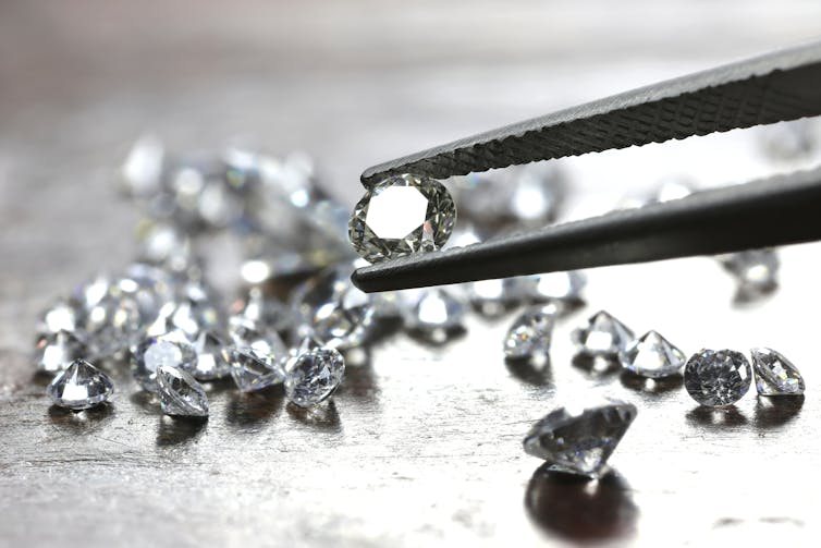 Diamonds with one held in tweezers