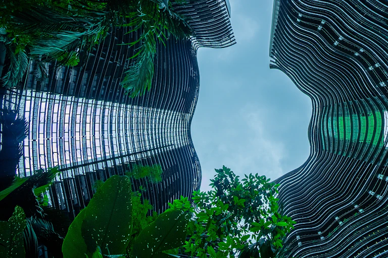 Trees surrounded by a tall glass building.