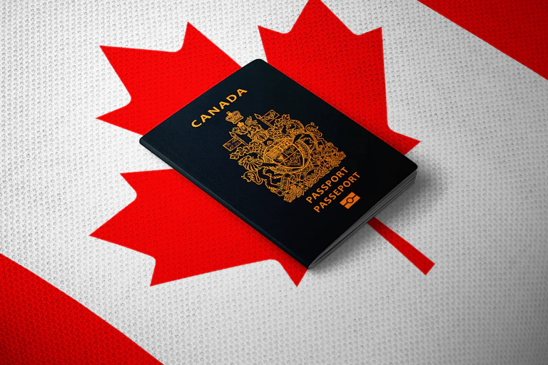A Canadian passport sits on a Canadian flag.