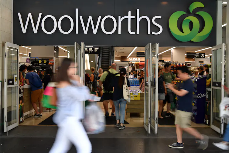 Woman walking past a supermarket