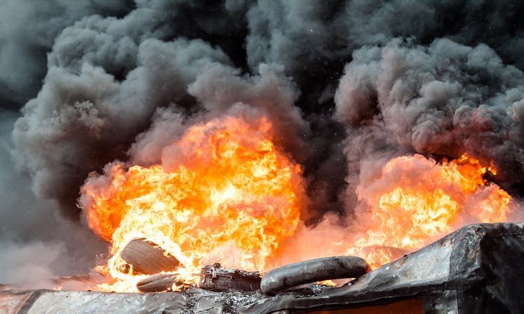 Fire and black smoke engulfing rubber tyres.