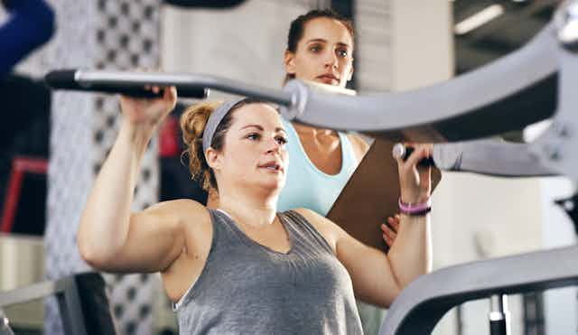 Woman in gym with trainer