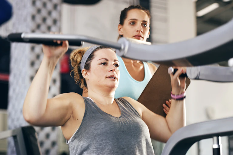 Woman in gym with trainer