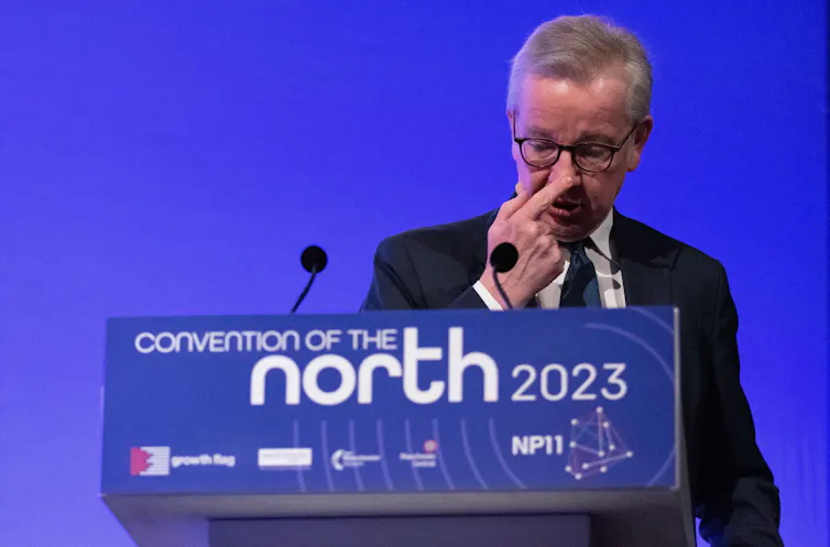 Grey-haired politician pokes his nose while speaking at a conference