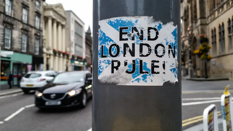 Sticker poster on a lamppost with cars behind