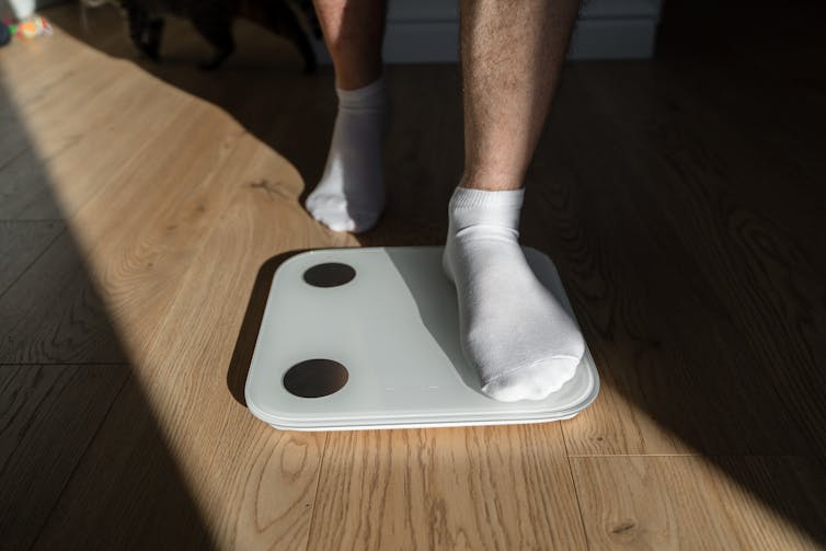 Close-up of a person's socked feet stepping on a scale
