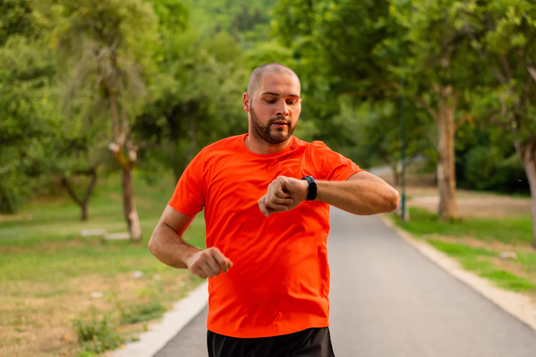 A man running and looking at his watch.
