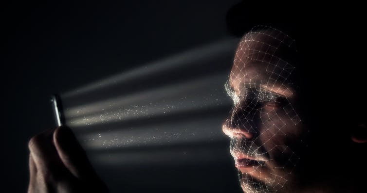a man's face being scanned by his mobile phone