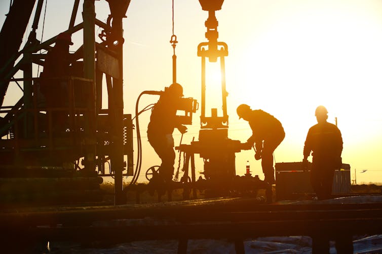 Oil workers drilling for oil.