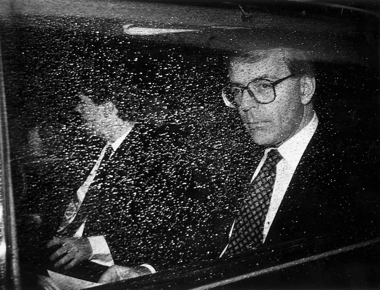 John Major looking displeased in the back of a car.