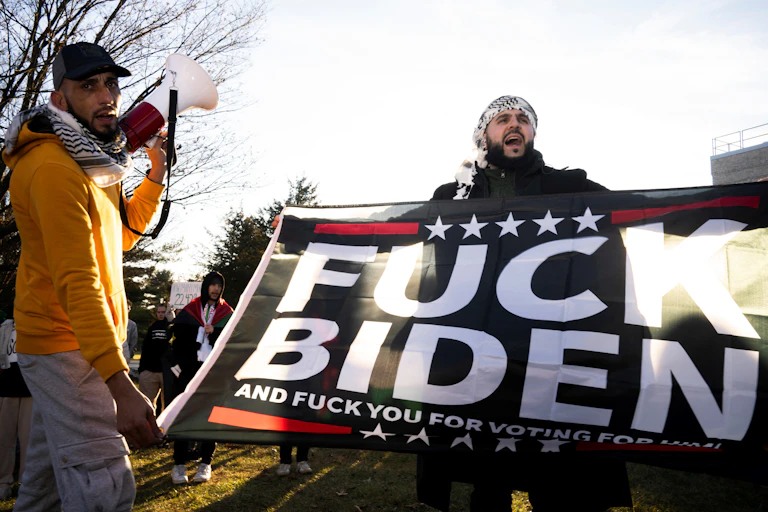 Homme tenant affiche proclamant « Fuck Biden »