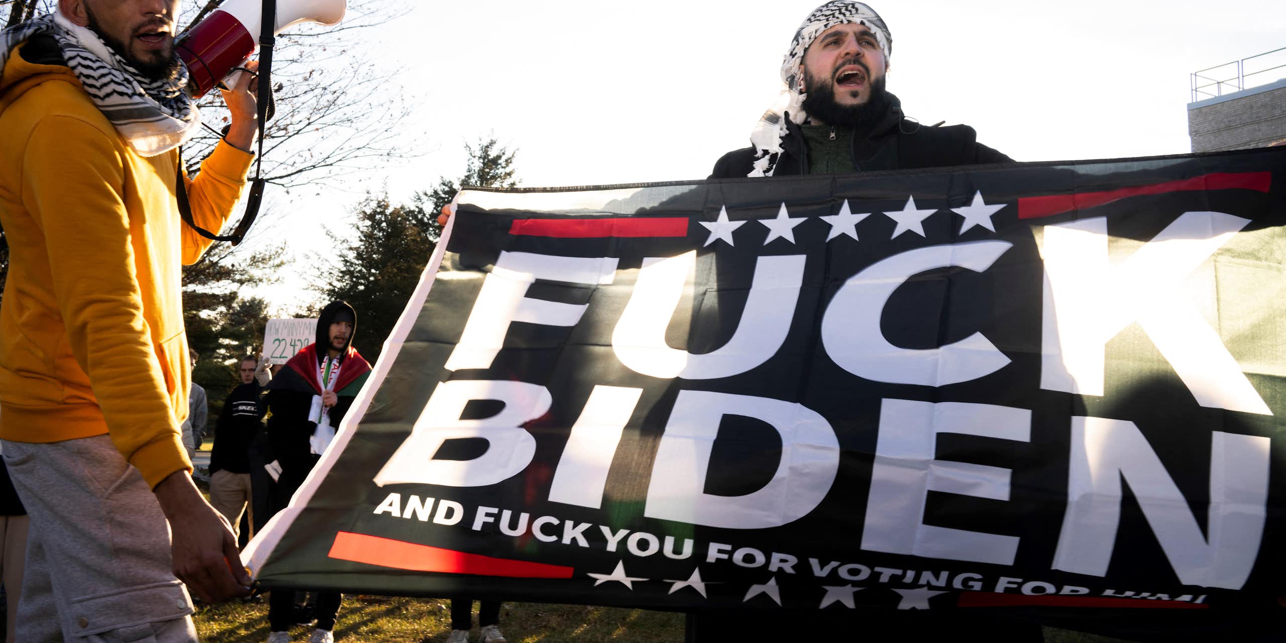 Homme tenant affiche proclamant « Fuck Biden » 