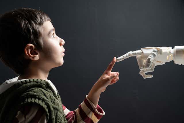Child touches finger of humanoid robot