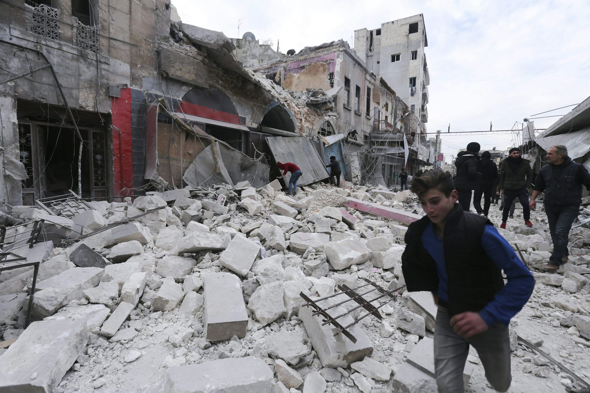 Des hommes circulent dans une rue en ruine