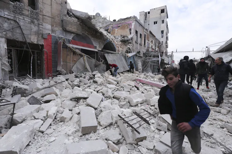 Des hommes circulent dans une rue en ruine