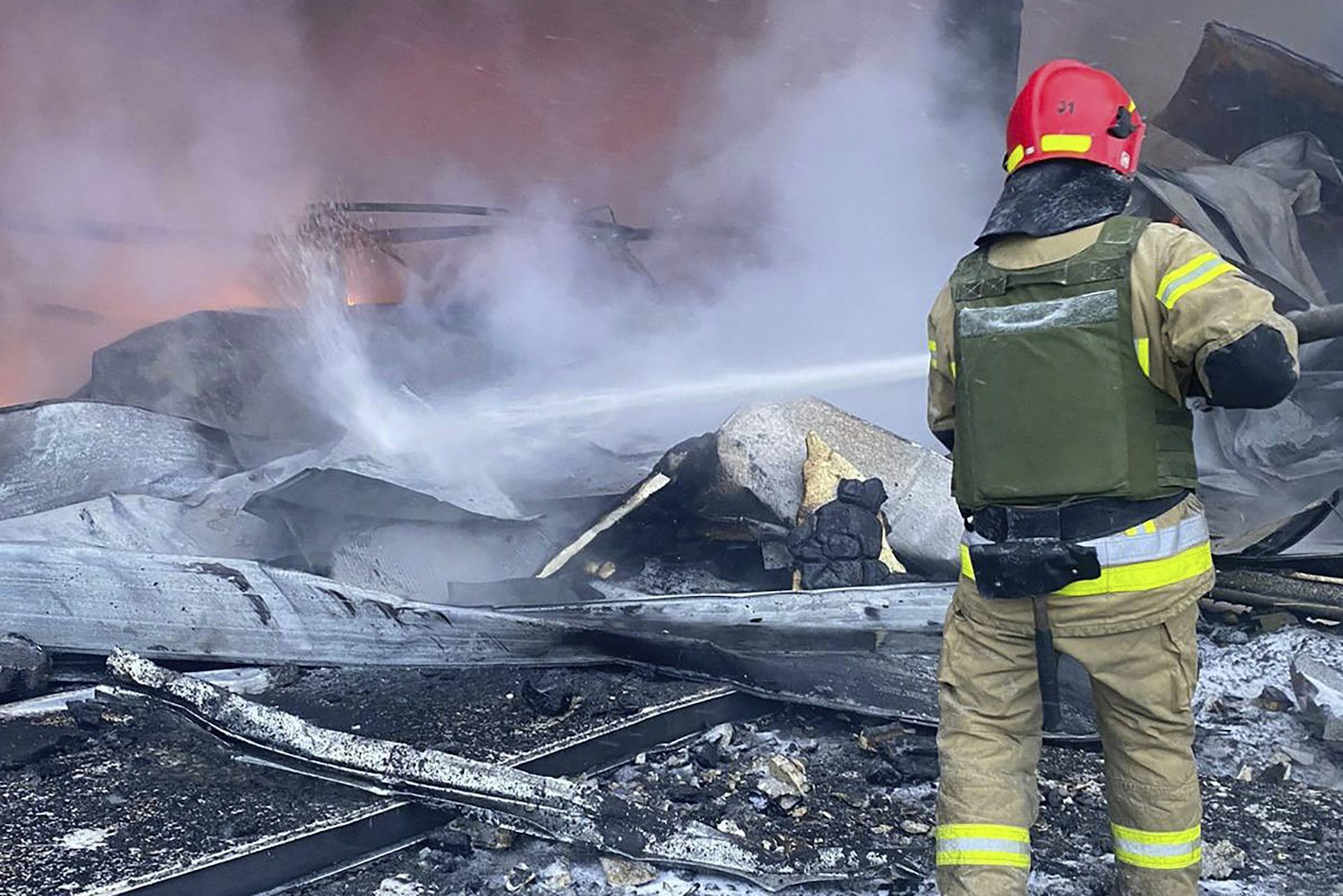 Un pompier éteint un incendie dans un bâtiment en ruine