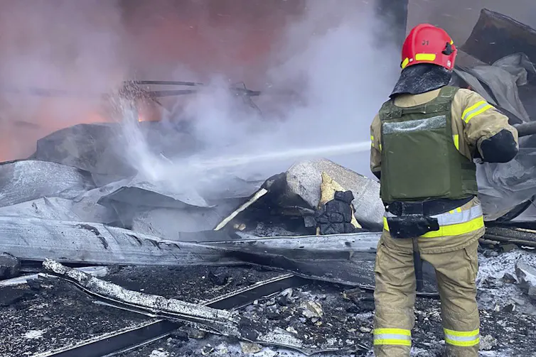 Un pompier éteint un incendie dans un bâtiment en ruine