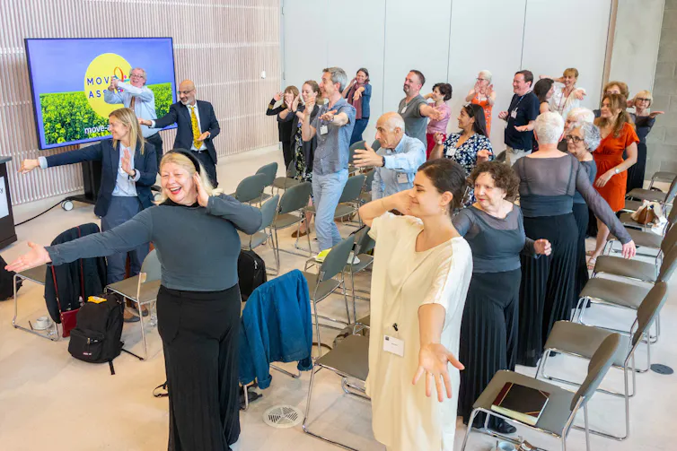 People at a talk in a meeting room dancing.