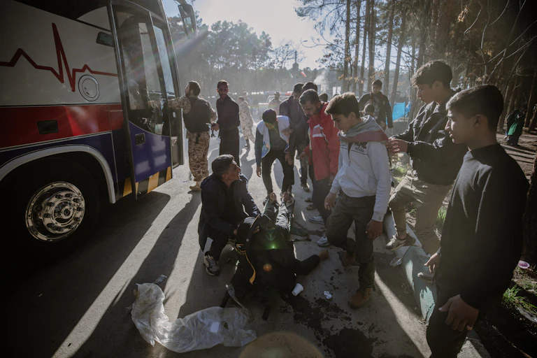 People gather around a stretcher with an injured person lying on it.