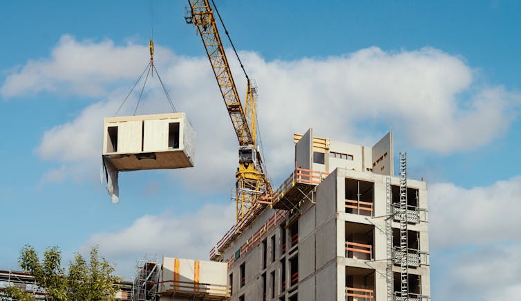A crane lifts a module into position in a Berlin office block being built using a modular timber construction process.