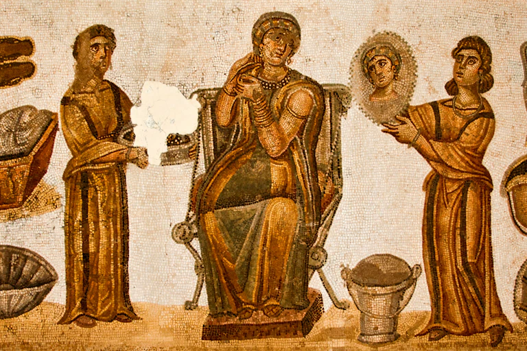 Mosaico que representa a una mujer en el baño con otras dos figuras que la ayudan a arreglarse.