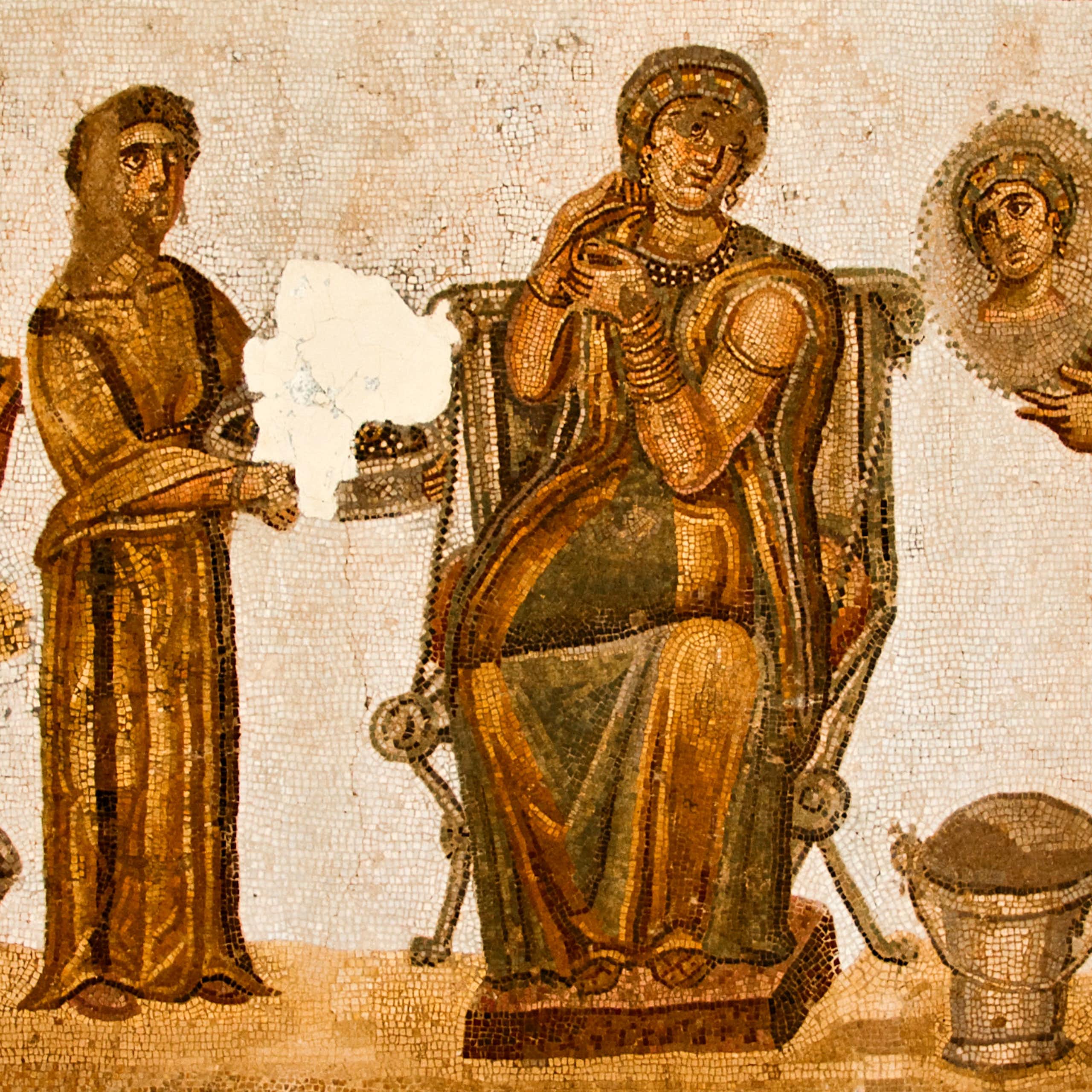 Mosaico que representa a una mujer en el baño con otras dos figuras que la ayudan a arreglarse.