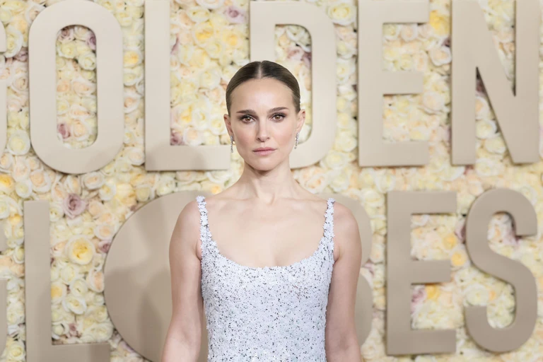 Natalie Portman on a red carpet in an embellished white gown.