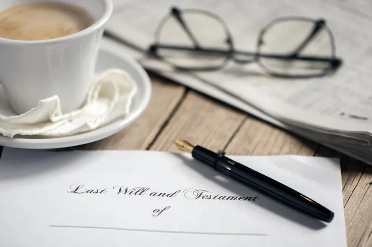 Cup of coffee, glasses, pen and paper that says Last will and testament of.