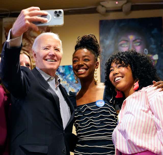 An older man takes a selfie of him and four women. All smile up at the phone.