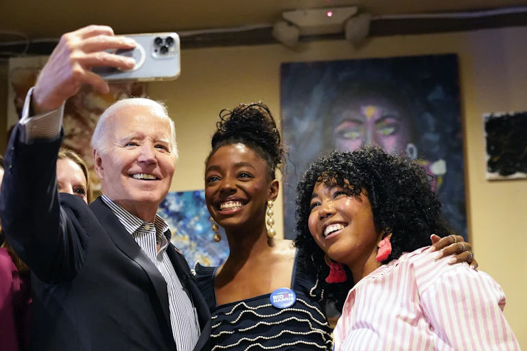 An older man takes a selfie of him and four women. All smile up at the phone.