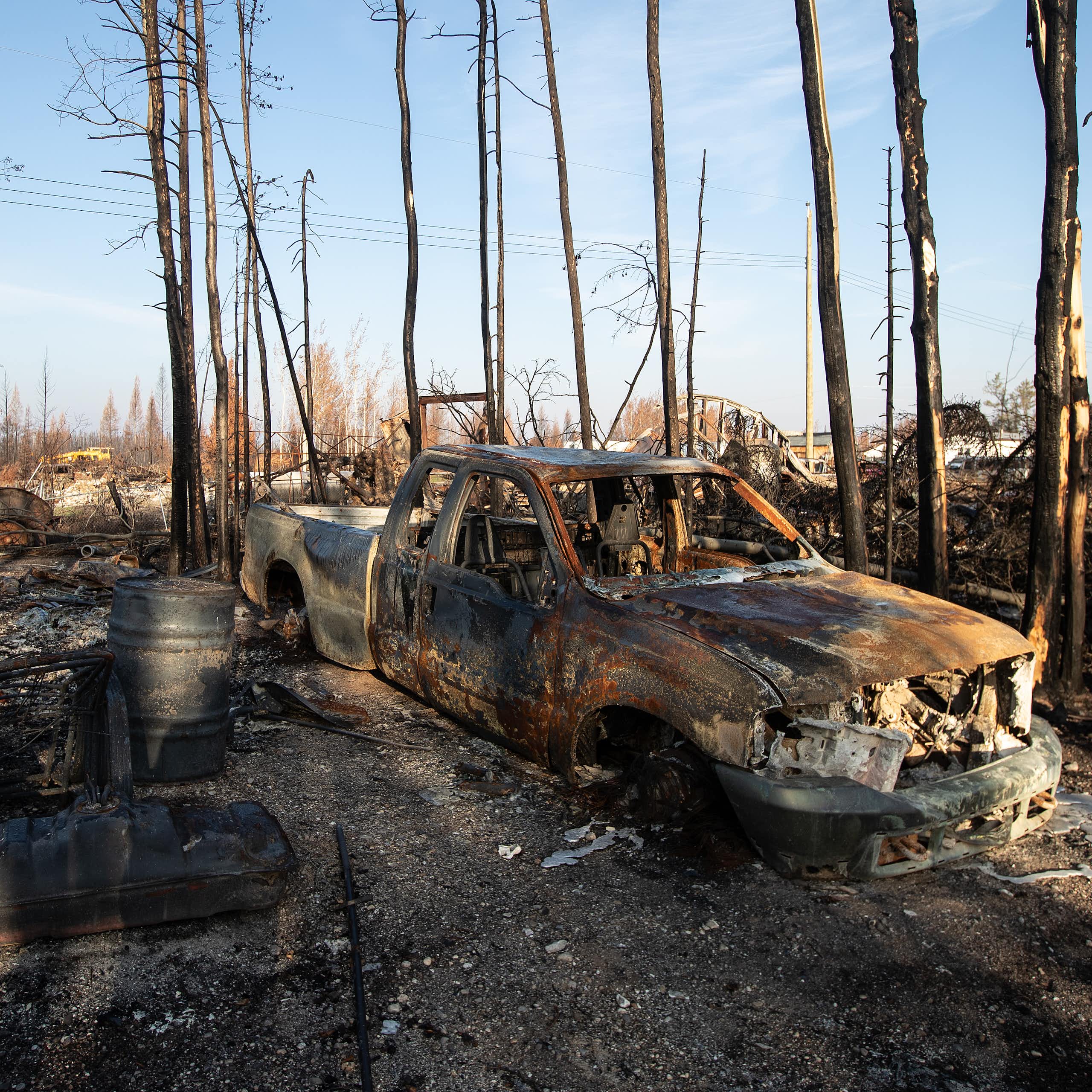 A burned out truck and assorted rubble is seen in the aftermath of a forest fire.