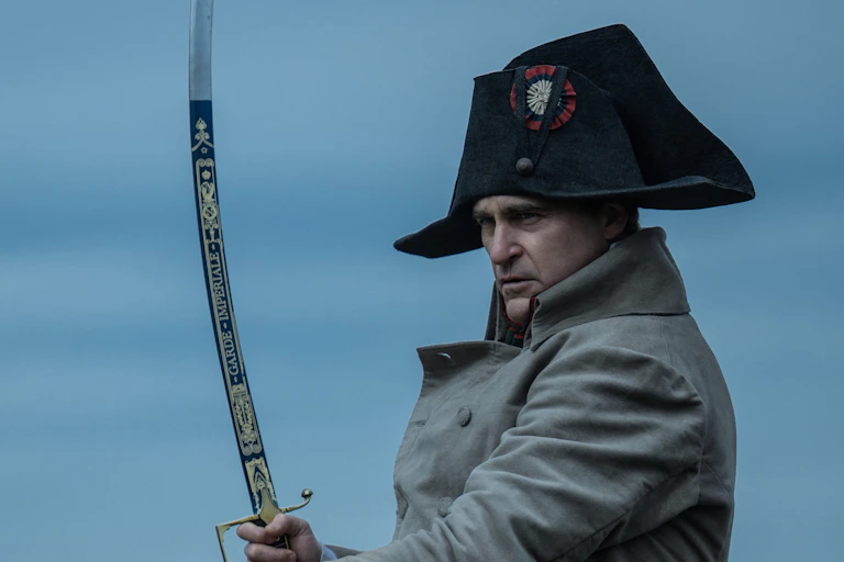 Un homme vêtu d'un bicorne noir et d'un manteau beige tenant une épée