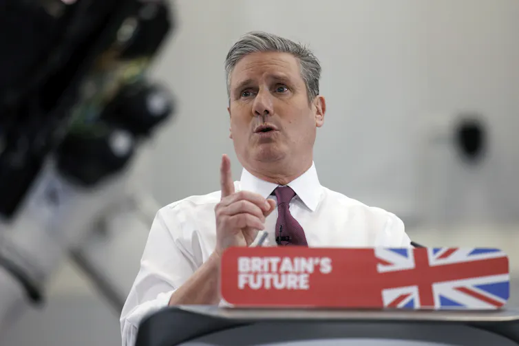 A man addresses a press conference behind a lectern reading 'Britain's future'
