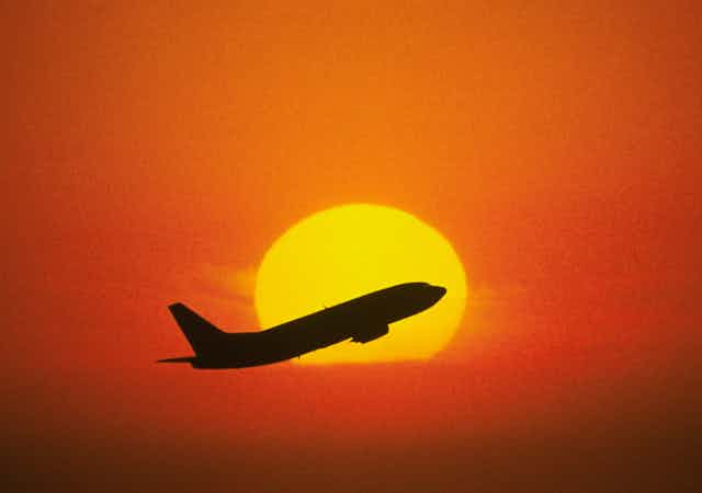Boeing 737 rising up into a sunset
