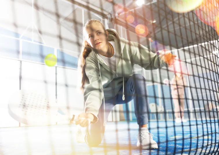 Adolescente jouant au tennis et montant au filet