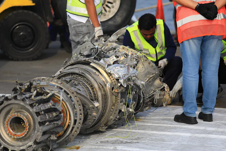 Indonesian investigators examining recovered plane parts in 2018.