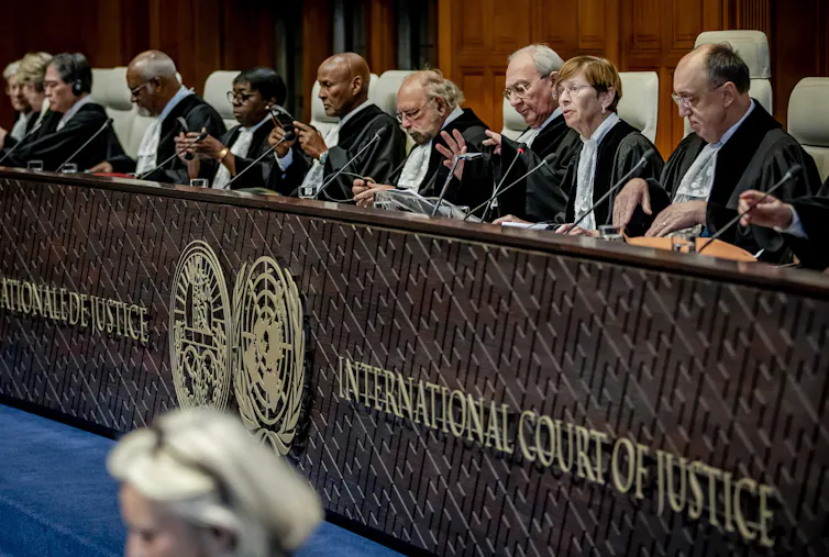 A long panel of judges sit behind a bench that reads 'International Court of Justice'