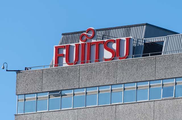 A Fujitsu sign on the top of a building. 