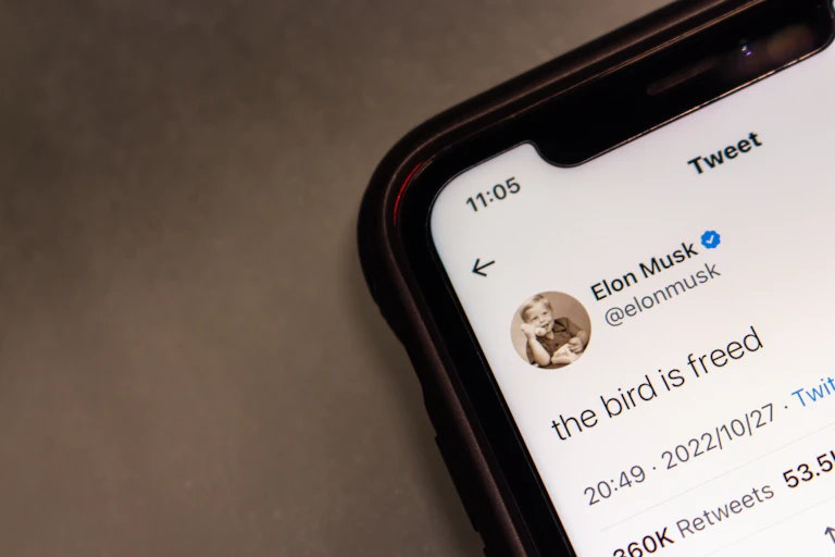 Photo of a phone with a tweet from Elon Musk: "the bird is freed".