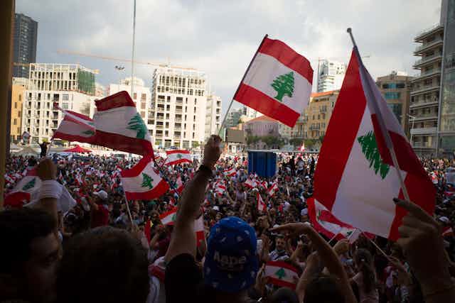 Protestors in Lebanon holding the Lebanese flag aloft.