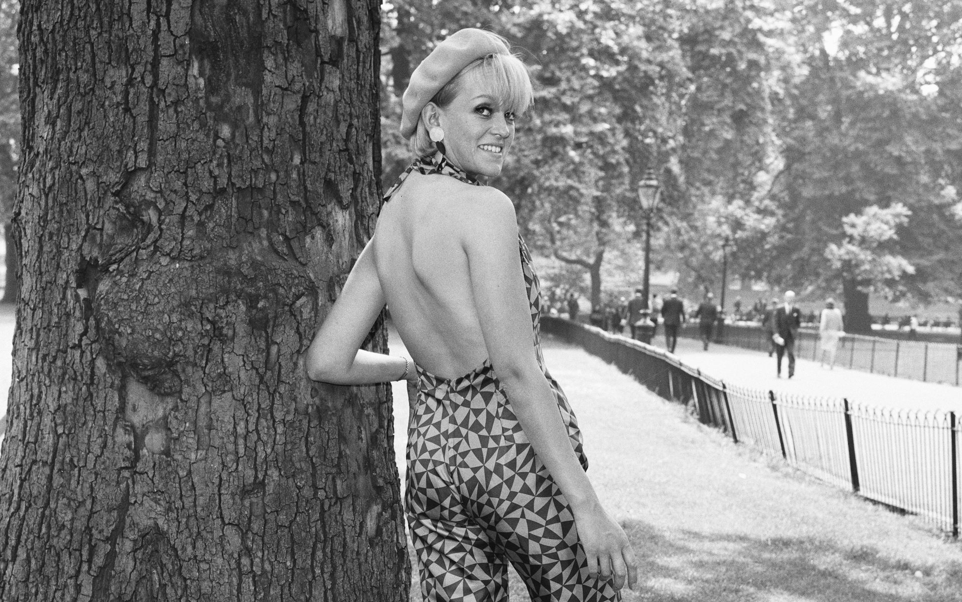 Annie Nightingale in a park wearing a catsuit.